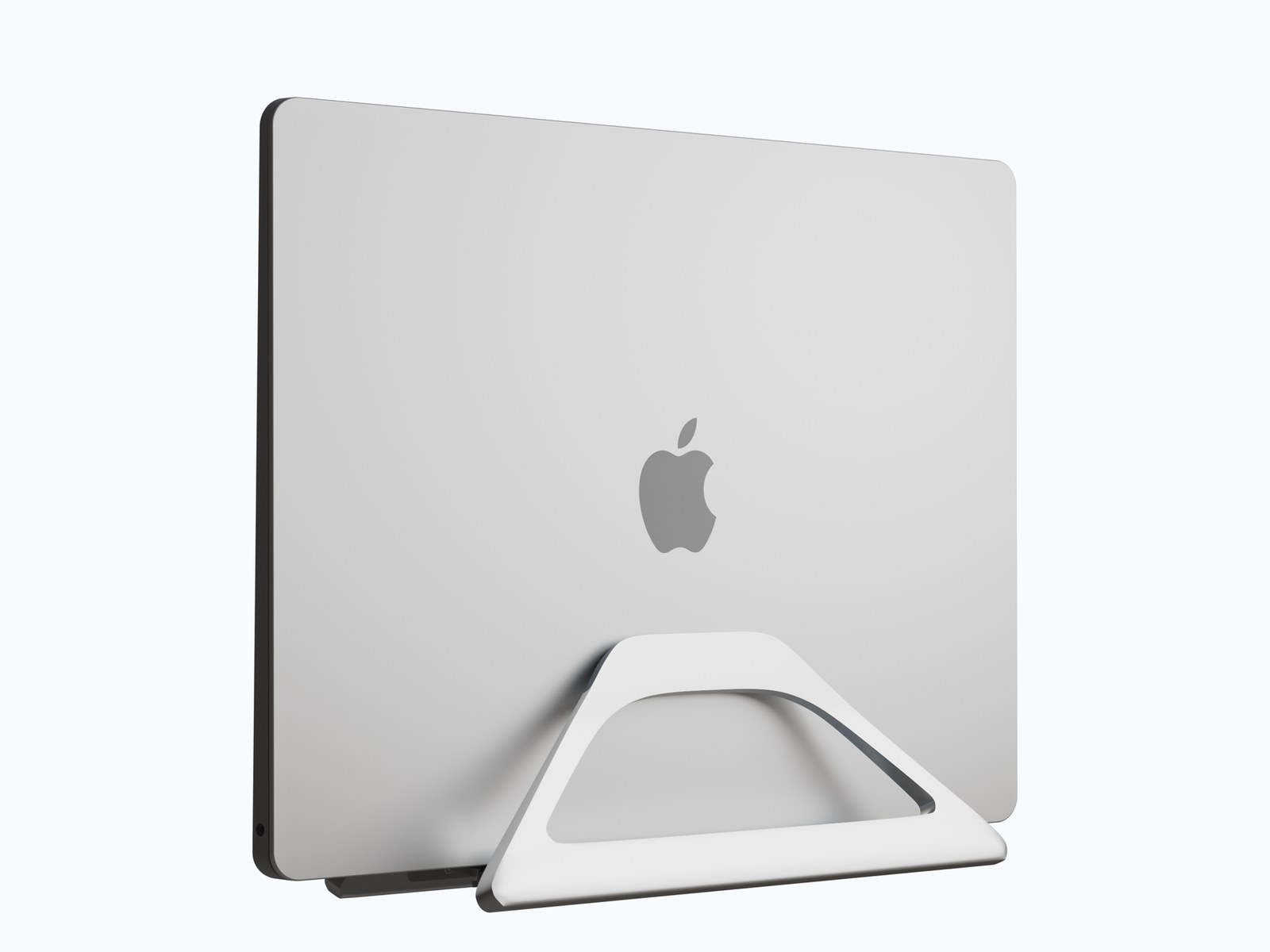 Production gravity dock holding a closed laptop upright on a desk, three-quarter view